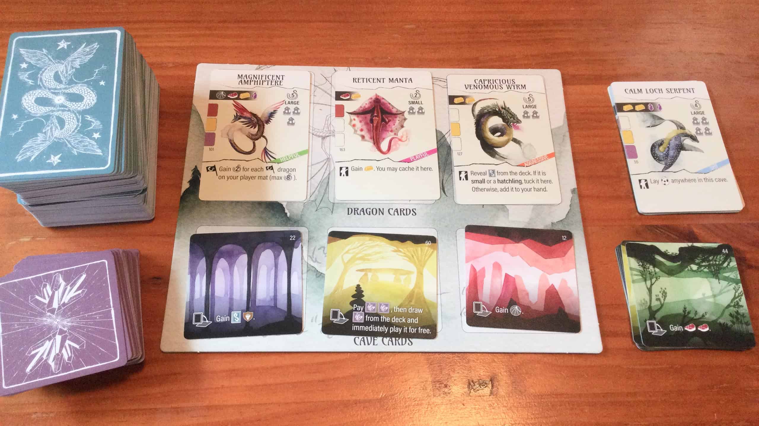 Kortinnostolauta, jossa on kolme lohikäärmettä ja kolme luolakorttia.